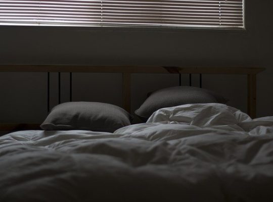Bett im abgedunkeltem Zimmer