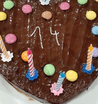 Schokokuchen mit Kerzen, Smarties und der Zahl 14