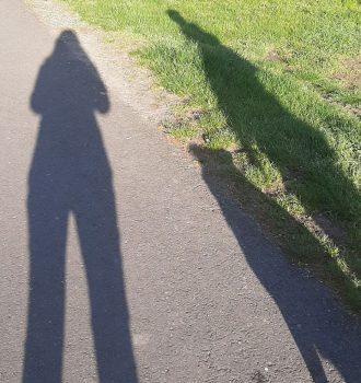 Schatten von zwei Menschen und einem Hund